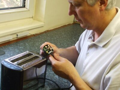 Technician PAT testing a toaster