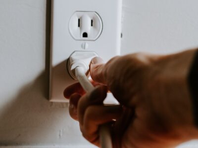 Person inserting plug into a socket in the wall